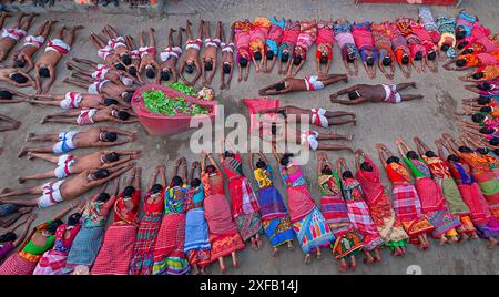 Devotees lie on the ground praying in front of the temple during the Shiv Gajan Festival. This sacred ritual, known as Agri . Stock Photo