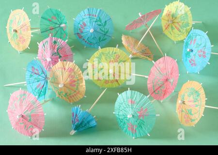 Multicolored Cocktail Umbrellas, spring and summer symbol, pastel green background, shallow depth of field Stock Photo