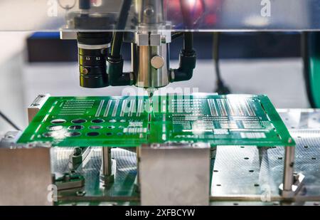 Technological process of assembly chip components on pcb board. Automated machine inside at industrial Stock Photo
