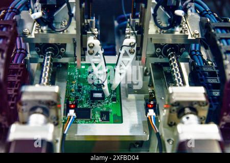 Technological process of assembly chip components on pcb board. Automated machine inside at industrial Stock Photo