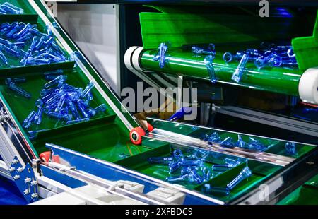 Blue Plastic bottles in production line at manufacturing PET perform, before bottles blowing in blowing machine at drink water factory. Stock Photo