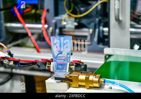 The operation of automatic plastic glass production line machine Stock Photo