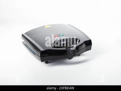 Black modern sandwich maker on a white background, isolate, close-up. Making toast and sandwiches, technology Stock Photo