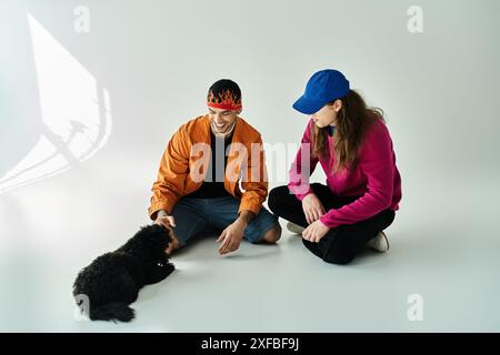 two men sit beside a black dog, sharing a peaceful moment. Stock Photo