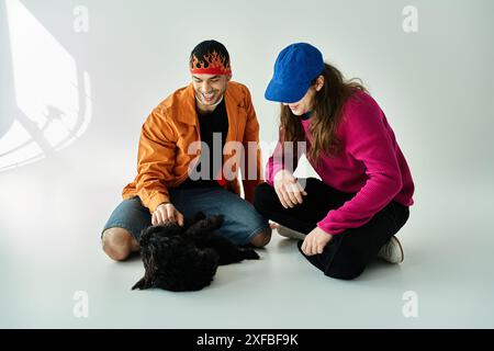 A gay couple and their furry companion sit peacefully on the ground. Stock Photo