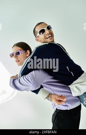 A man effortlessly carries partner on his back in a display of strength and affection. Stock Photo