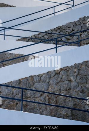 staircase with iron railings among a stone wall with a white top. Modern home design. Mallorca, Spain Stock Photo