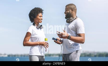 Black Couple Talking Before Morning Jog Along River Bank Stock Photo