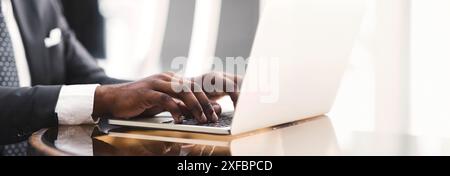 Closeup of businessman's hands working on laptop computer in cafe Stock Photo