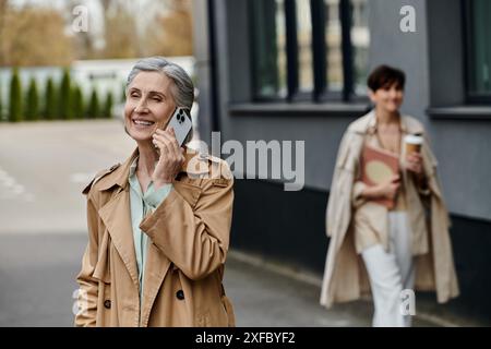 Woman chatting on phone while strolling along street with her partner. Stock Photo