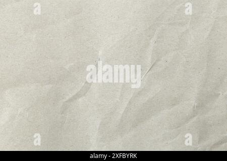 A grey paper with a grainy texture. The paper is wrinkled, giving it a rough and worn look. Stock Photo
