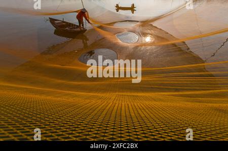 Local fisherman catching fish at dawn on the Thu Bon River in Cua Dai fishing village near Hoi An, Central Vietnam, Asia in June Stock Photo