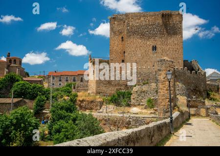 Captivating view of Davila Castle and the medieval bridge over the Tormes river in Puente del Congosto, Salamanca, Spain. Stock Photo