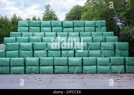 Stacks of wrapped bales of hay on a farm Stock Photo