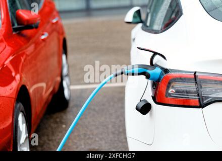 Electric car ev hybrid charging charger outdoors in a city Stock Photo