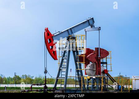 Oil drilling derrick pumps oil from ground. Petroleum industry, crude oil extraction. Production of fuel from natural resources. Oil crisis. Stock Photo