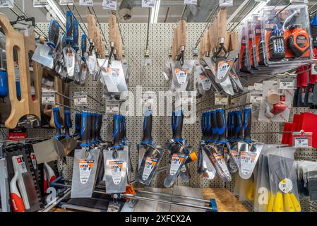 Italy - March 23, 2024: Plastering tools displayed on the shelf of a DIY store, trowels and painter's trowels, meters displayed in the masonry supplie Stock Photo