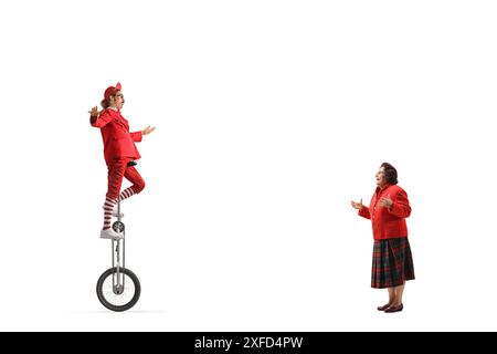 Elderly woman watching an acrobat riding a giraffe unicycle isolated on white background Stock Photo