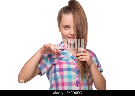 Haircut at hairstylist at a hairdresser. Teen Caucasian girl hairdresser in hair salon. Hairstylist working in a hair salon. Hairdresser teen girl Stock Photo