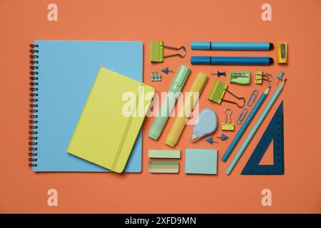 Flat lay composition with notebooks and different stationery on orange background Stock Photo