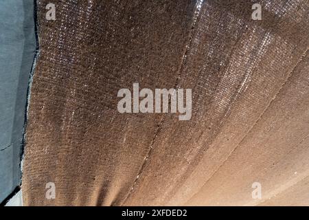 Close-up view of sturdy brown shelter fabric with visible weave pattern. Provides refuge from harsh desert conditions in Merzouga, Morocco. Stock Photo