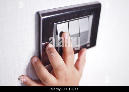 child finger turning on lighting switch with copyspace  Stock Photo