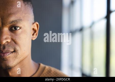 Looking confidently, businessman standing near office window, copy space Stock Photo