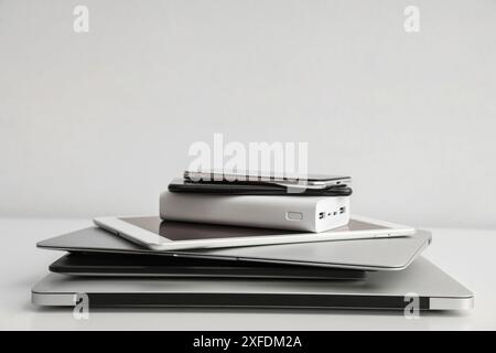 Stack of different modern gadgets on light background Stock Photo