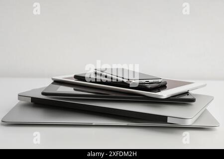 Stack of different modern gadgets on light background Stock Photo