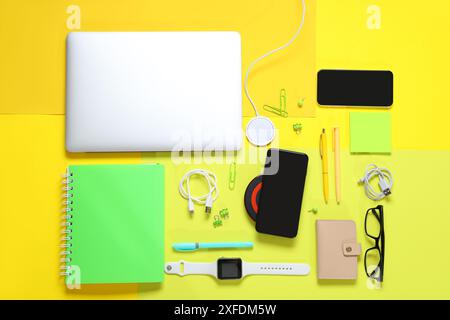 Composition with different modern gadgets and stationery on yellow background Stock Photo