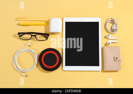 Composition with modern gadgets, accessories and pens on color background Stock Photo