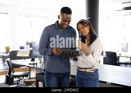 Business colleagues using tablet and smartphone, collaborating in modern office Stock Photo