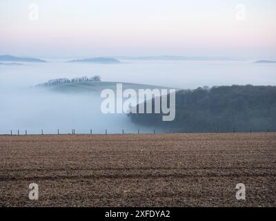 Mist filled valley from the B3081 on Cranborne Chase to the valley of the A30 near Shaftesbury, Dorset, England, UK, March 2020 Stock Photo