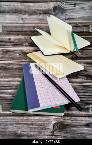 Notebooks and stationery placed on wooden table. Stock Photo