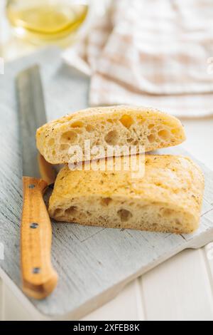 Italian ciabatta bread on cutting board on a white table. Stock Photo