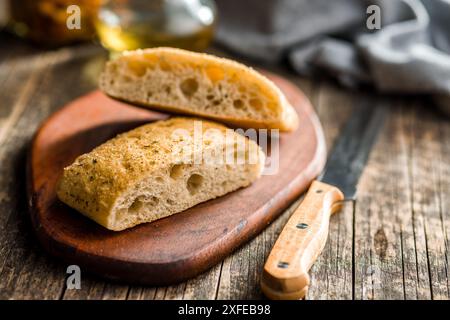 Italian ciabatta bread on cutting board on a wooden table. Stock Photo