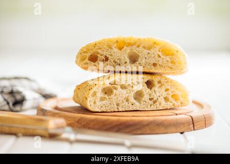 Italian ciabatta bread on cutting board on a white table. Stock Photo