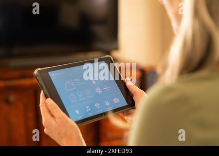 Using tablet for controlling smart home devices, woman managing home automation Stock Photo