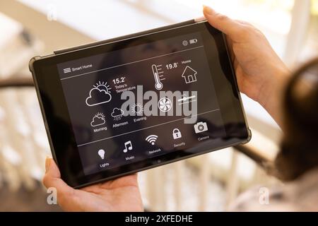 Using tablet to control smart home system, adjusting temperature and settings Stock Photo