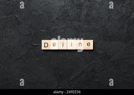 Define word written on wood block. Define text on cement table for your desing, concept. Stock Photo