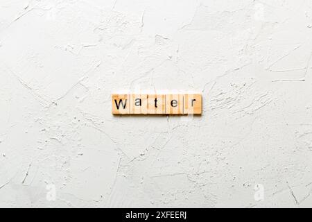 water word written on wood block. water text on cement table for your desing, concept. Stock Photo