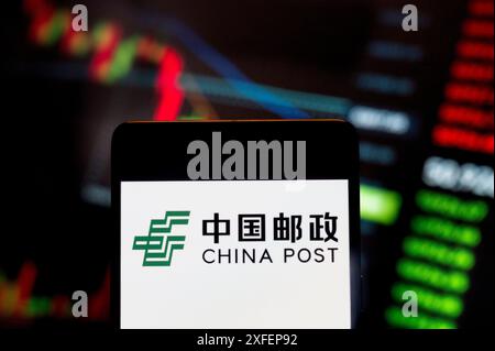 China. 23rd June, 2024. In this photo illustration, the Chinese national postal service corporation China Post logo seen displayed on a smartphone with an economic stock exchange index graph in the background. (Credit Image: © Budrul Chukrut/SOPA Images via ZUMA Press Wire) EDITORIAL USAGE ONLY! Not for Commercial USAGE! Stock Photo