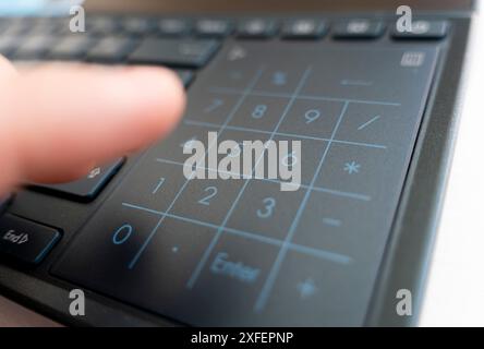 hands using a computer. fingers typing a laptop. Laptop keyboard being used by hands. the finger presses the numbers on the keyboard. Electronic numpa Stock Photo
