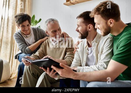A gay couple shares a photo album with parents, creating a loving and heartwarming family moment. Stock Photo