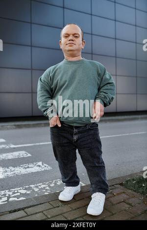 A man with inclusivity stands on a city sidewalk, looking confident and ready to embrace his day. Stock Photo