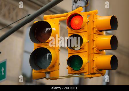 Iconic American yellow traffic lights hanging from an overhead gantry in New York City. Stock Photo