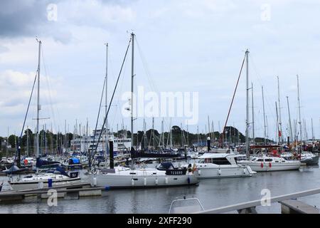 Lymington Harbour, England. 18 June 2024. Sailing boats with tall masts, docked in the marina. Stock Photo