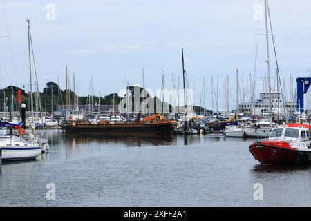 Lymington Harbour, England. 18 June 2024. Scene in the marina with a Berthon crane beside a boat. Stock Photo