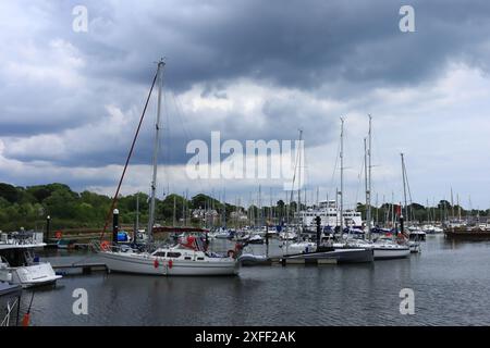 Lymington Harbour, England. 18 June 2024. Sailing boats in the harbour with a Wightlink ferry to Yarmouth in the distance. Stock Photo