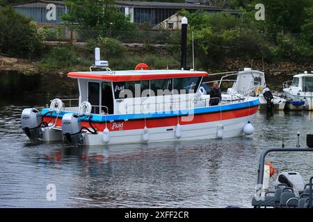 Lymington Harbour, England. 18 June 2024. Fluid, a red, blue and white boat cruising in the harbour. Stock Photo